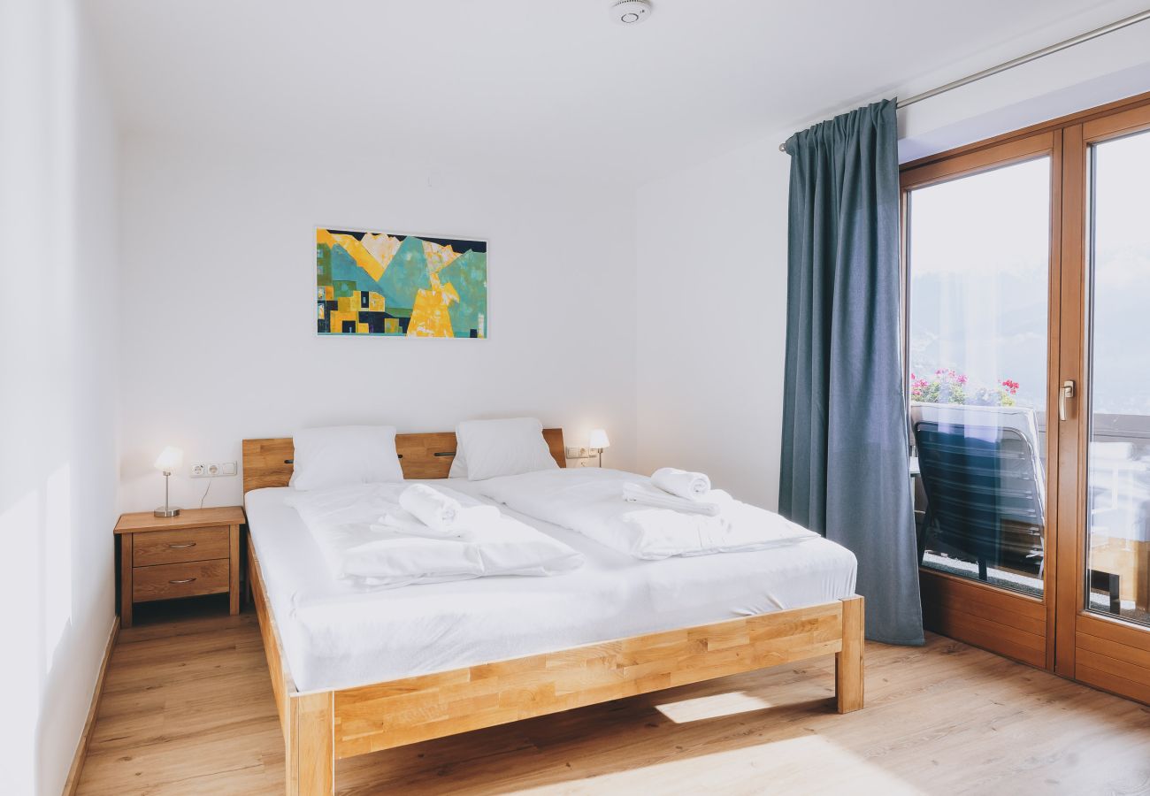 Bedroom in the holiday apartment Haus Altenberger Apartments by we rent. Double bed with access to the balcony and a view.