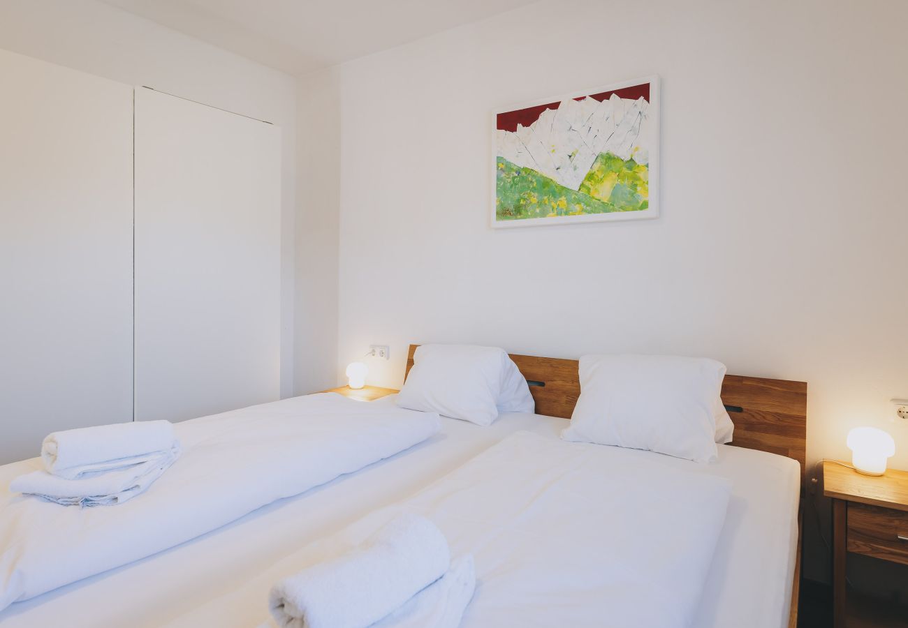 Bedroom in the holiday apartment Haus Altenberger Apartments by we rent. Cozy double bed with bedding.